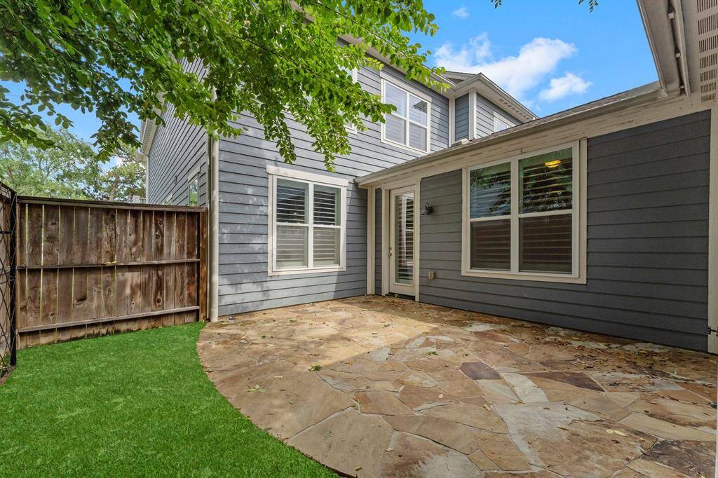 Charming private backyard with flagstone patio and low-maintenance turf, perfect for outdoor entertaining.