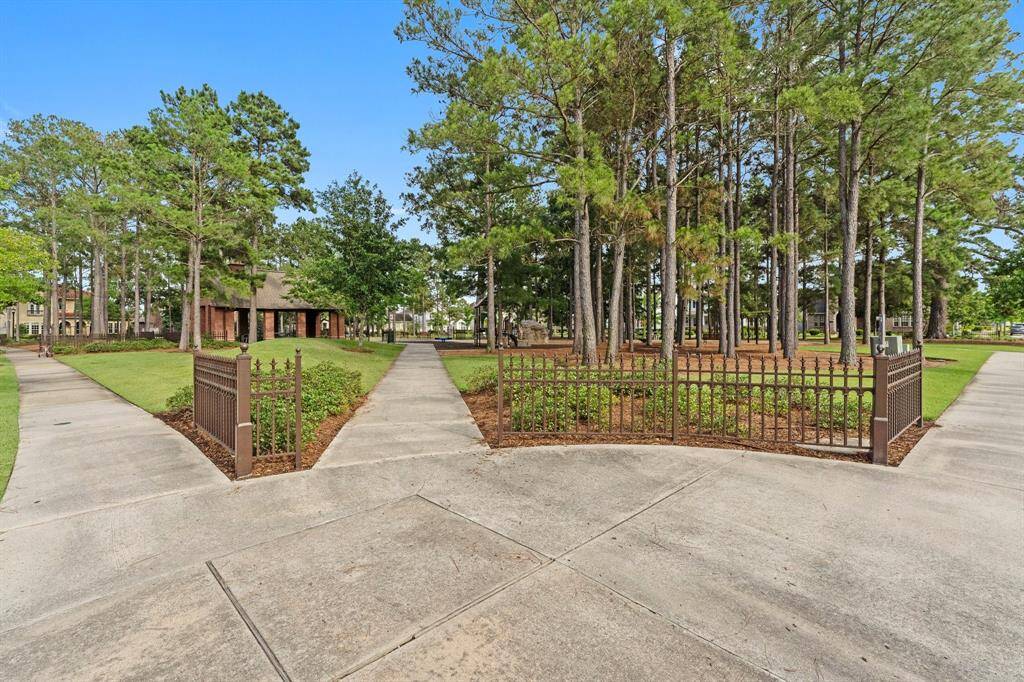 Community park with towering pine trees, manicured walkways, and a charming pavilion perfect for outdoor gatherings.
