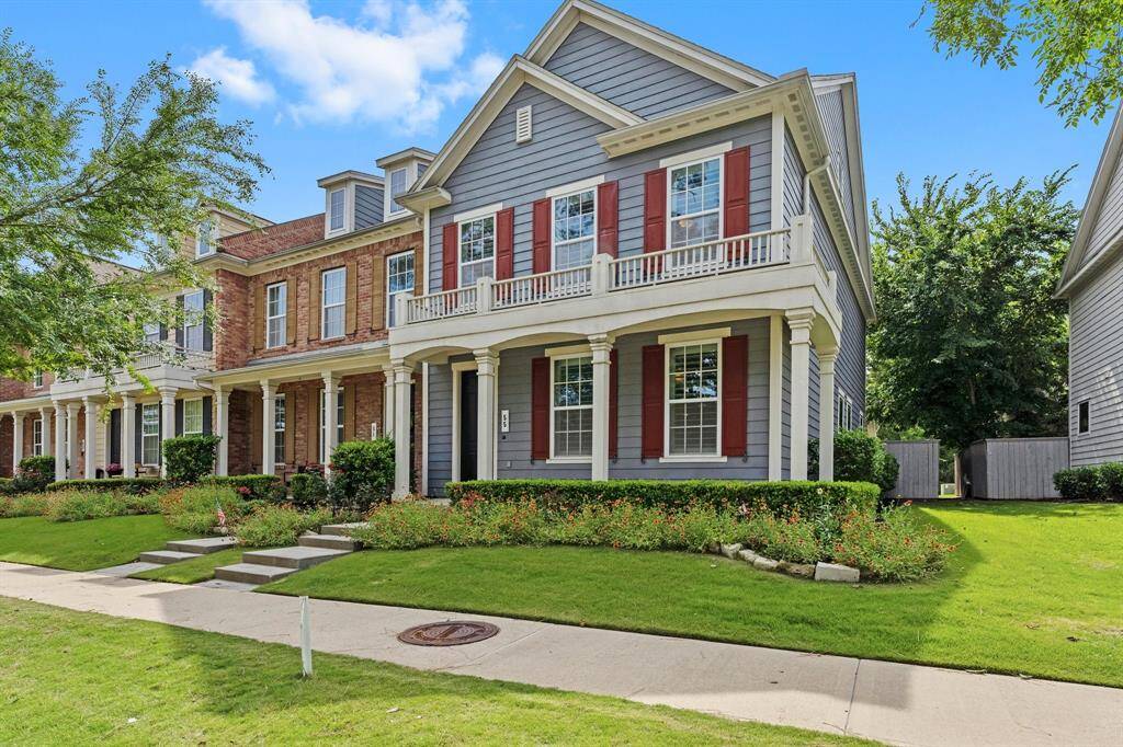 Beautifully maintained two-story home with charming red shutters, upper and lower porches, and lush landscaping in a desirable neighborhood setting.
