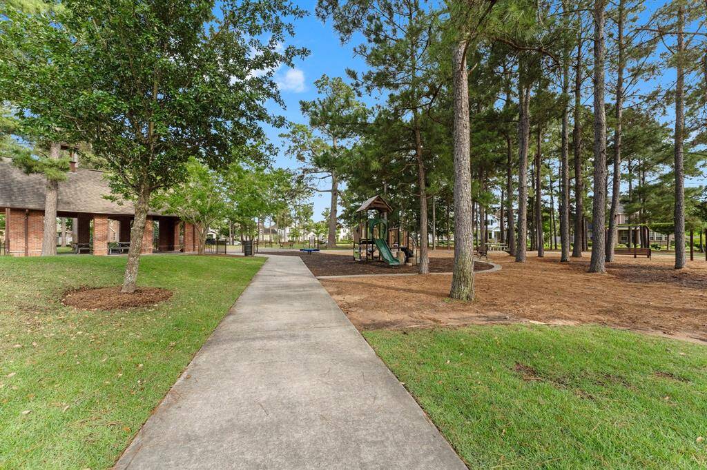 Community amenities include a shaded playground, picnic pavilion, and scenic walking paths surrounded by mature trees.