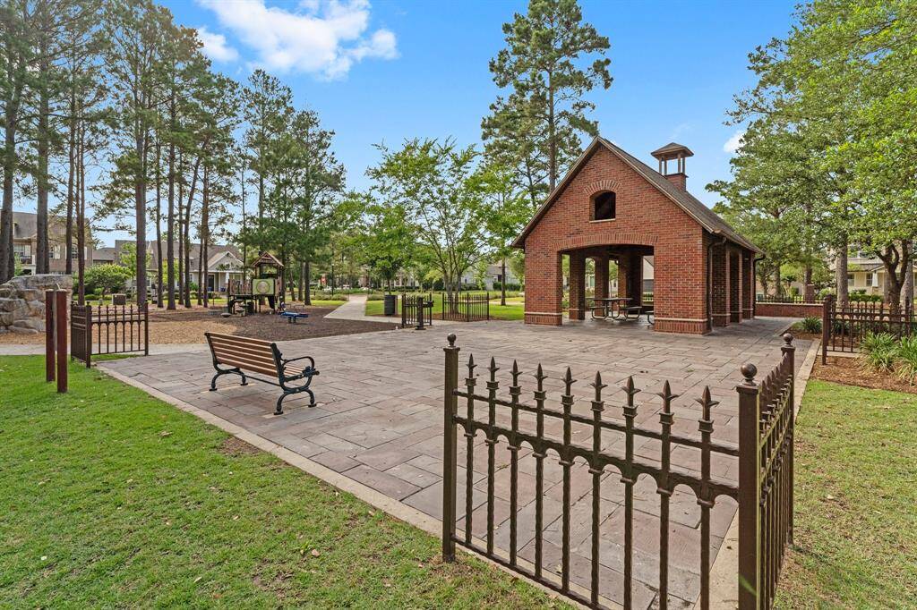 Charming community park featuring a covered pavilion, benches, and a fenced playground—perfect for outdoor gatherings and family fun.