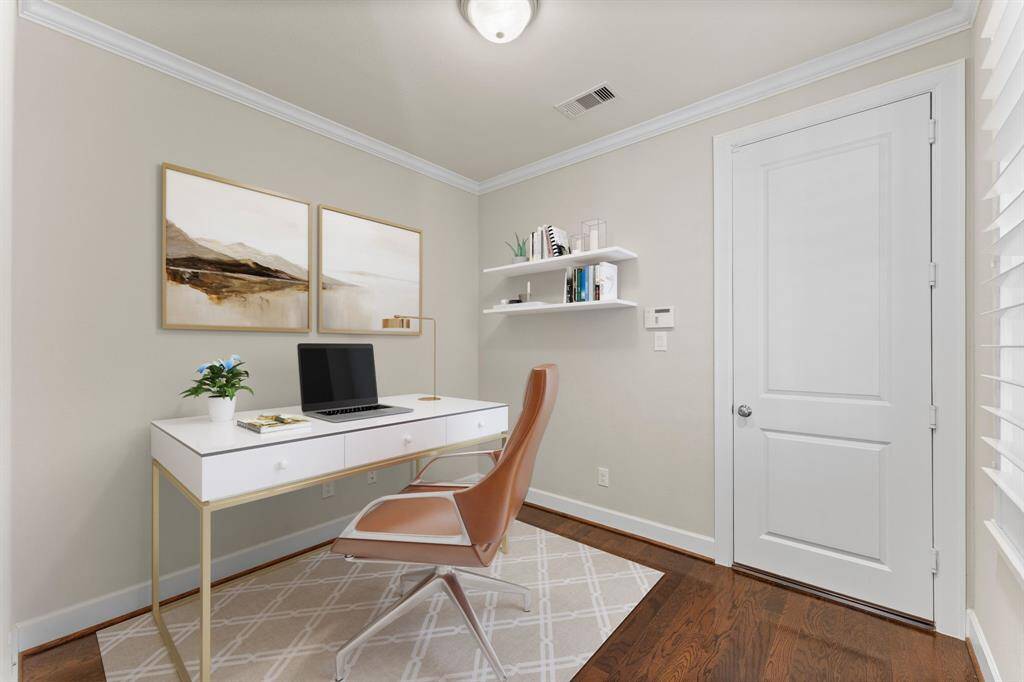 This bright and versatile space is perfect for a home office or study nook, featuring crown molding and hardwood flooring.