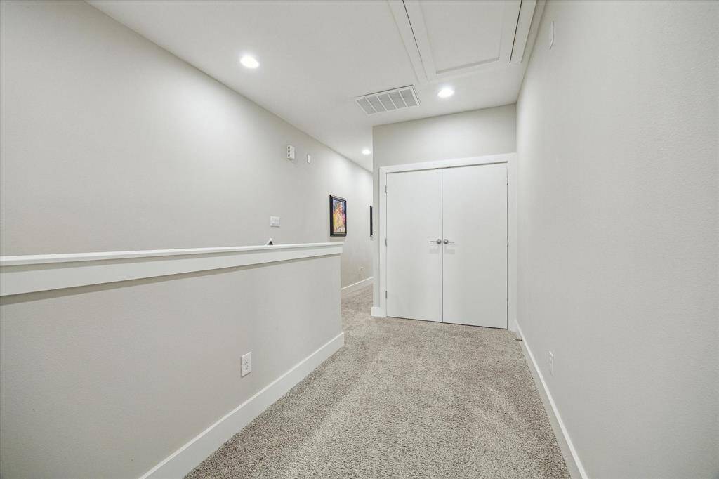 Hallway separating the primary suite and additional bedrooms.