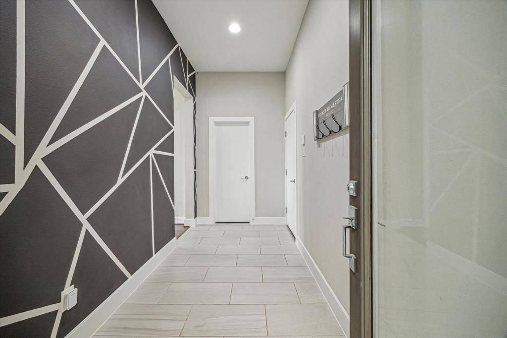 Formal foyer with half bath leads to kitchen, dining and living room. The attached garage is equipped with a Tesla wall connector level 2 hardwired electric vehicle charger for added convenience.