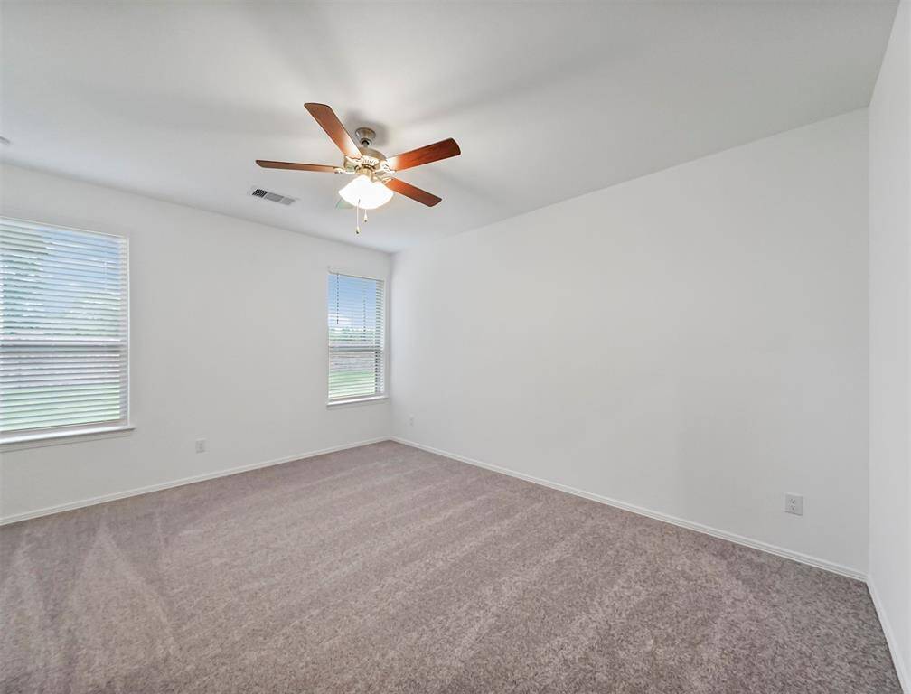 A look into this Elegant Primary Suite that offers Plush Carpeting, Ceiling Fan, Natural Lighting and views of the beautiful backyard