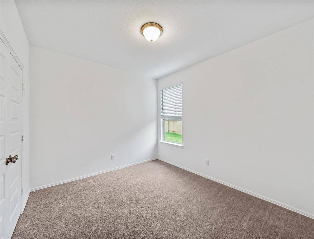 Splendid Secondary Bedroom located on the first floor is accompanied with plush carpeting, slanted ceilings, private closet, and view of the beautiful backyard. Great for guests and multigenerational families.