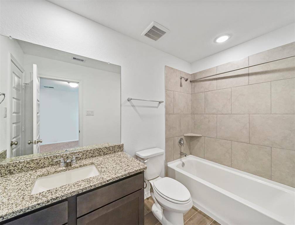An additional secondary bathroom also features granite countertops, shower/tub combo with tile surround and terrific tile flooring.
