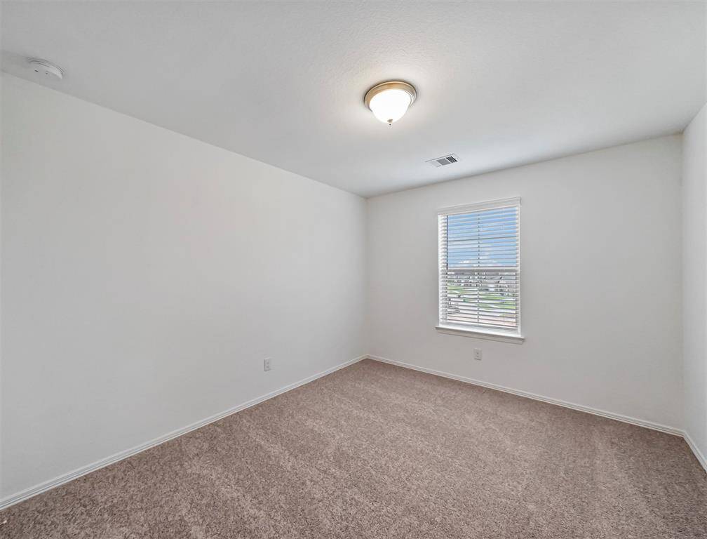 An abundance of natural light floods this Secondary Bedroom through the window and offers plush carpet and closet for wardrobe.