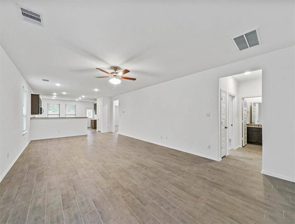 Luxurious Living Room offers tile flooring, natural lighting, ceiling fan and open concept that allows for ease of conversation from one main area to the next.
