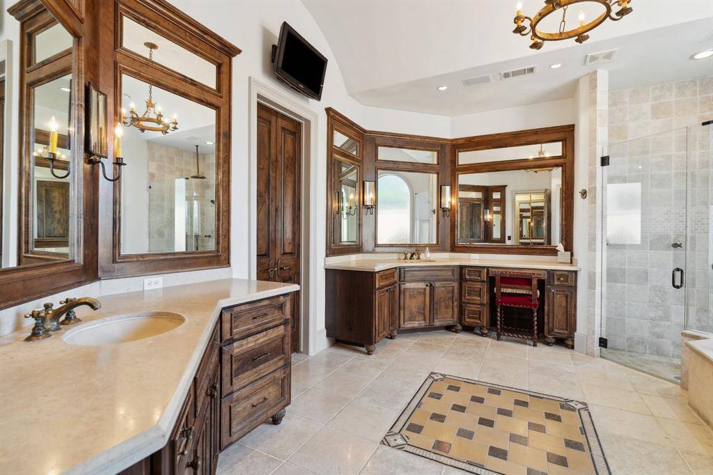 The primary bathroom features double sinks, a glass shower, separate tub, water closet and two walk-in closets.