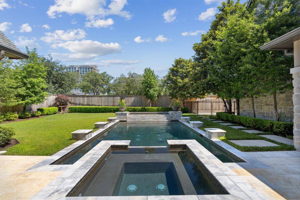 The backyard features a large pool and spa and greenspace.