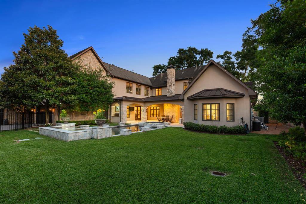 The home at night is truly spectacular, with the outdoor lighting casting a soft glow that highlights the shimmering pool and beautifully landscaped grounds.