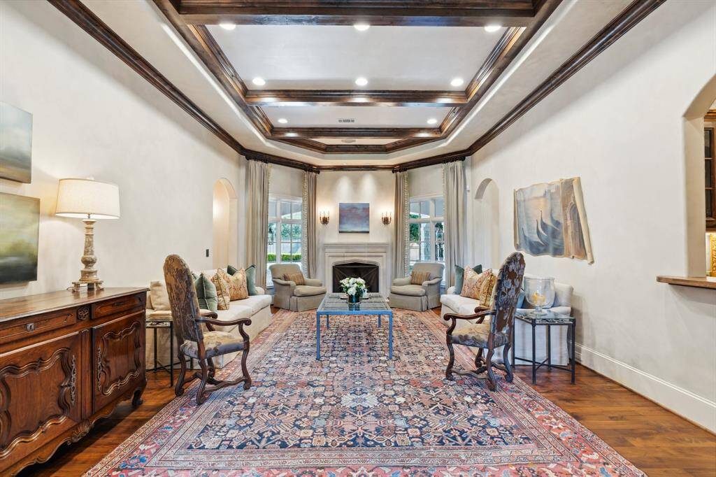 Spacious living room area with walnut hardwood flooring and gas log fireplace with limestone mantle.