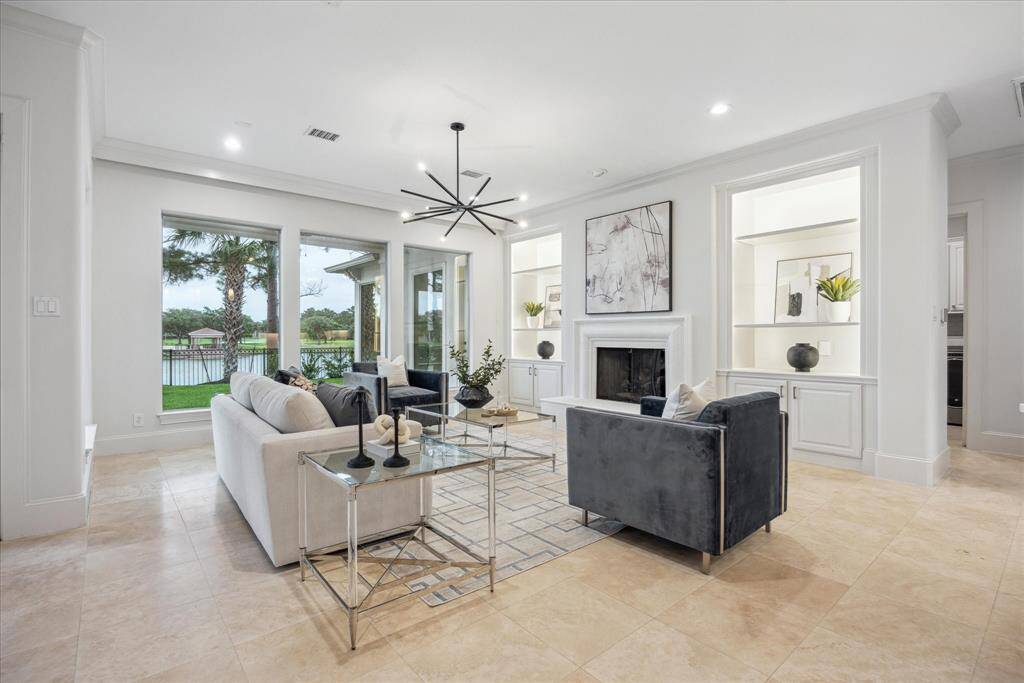 The family room features a custom gas fireplace with 3 tiered gas logs, creating a warm and inviting focal point. Custom-built-ins with lighting flank the fireplace.