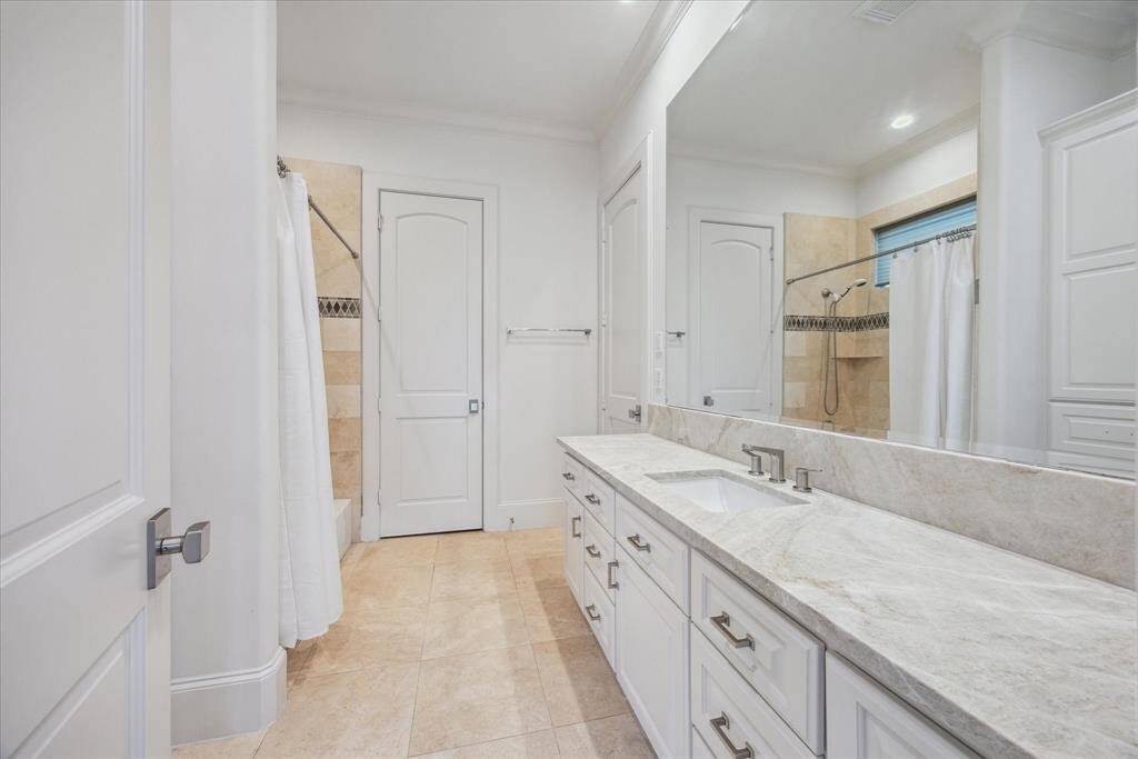The private ensuite bath features a large layout with tub shower combo, updated hardware, and elegant finishes.