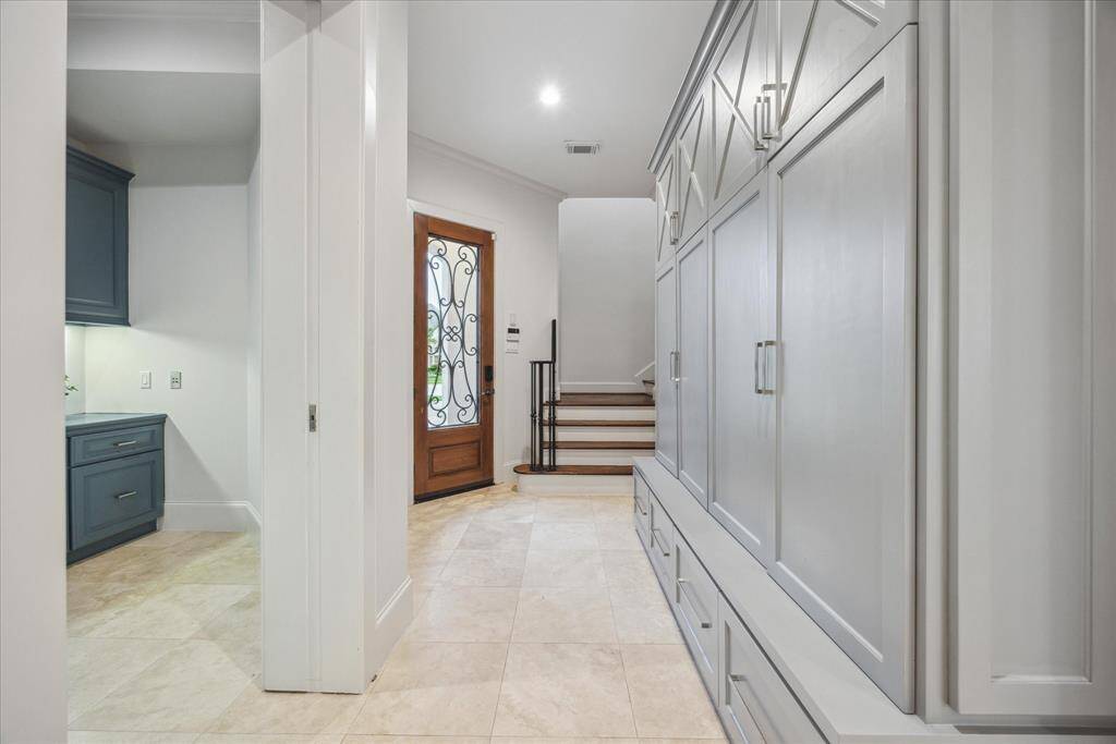 Located just off the side door entry, the mudroom offers a wall of custom built-in storage lockers with upper and lower compartments. It is perfect for organizing bags, shoes, and everyday essentials.