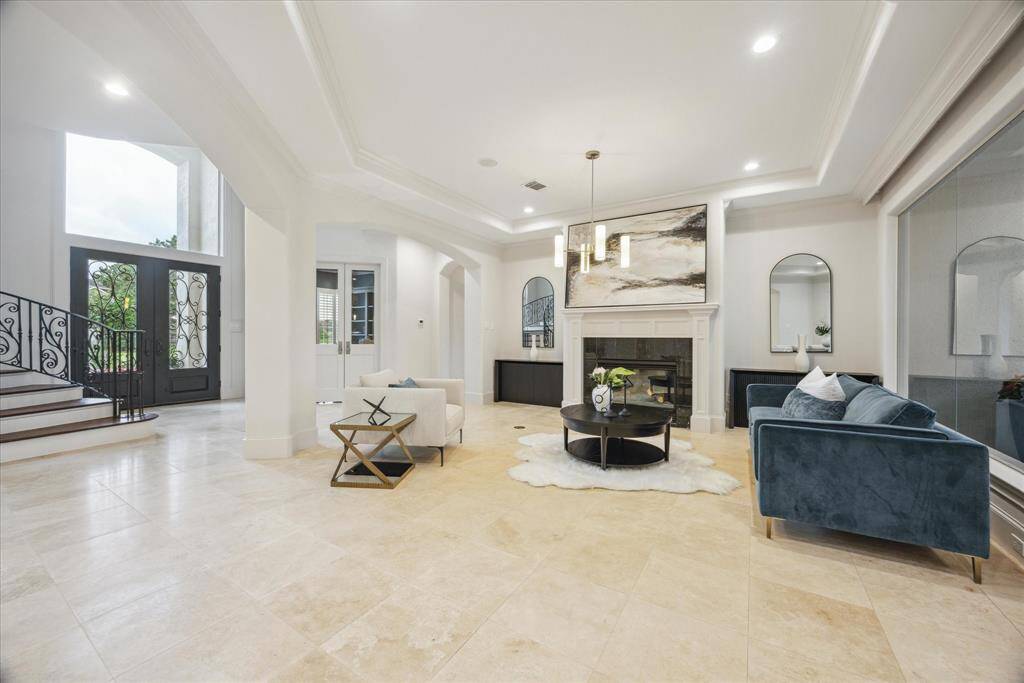 Passing through the formal living area, accented by elegant lighting, custom window treatments, and serene lake views.