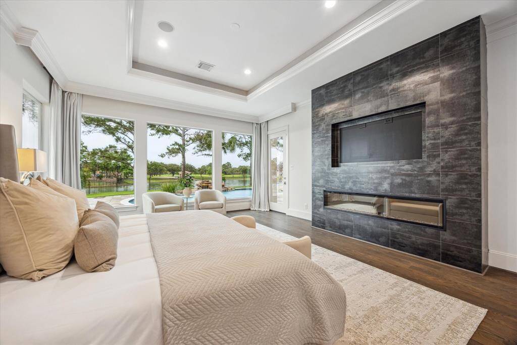 Custom tiled accent wall, and an elongated electric fireplace with multiple color settings and heat feature, this luxurious retreat blends comfort and sophistication with direct access to a spa-like ensuite bath and custom closet.