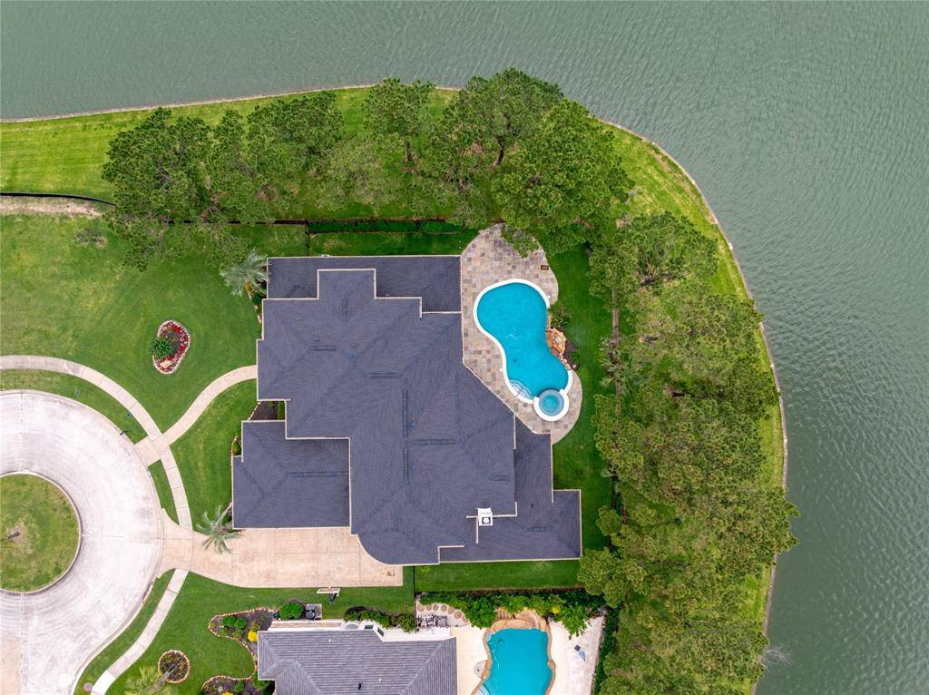 Aerial view showcases this prime cul-de-sac lot surrounded by water on two sides, just moments from community amenities.