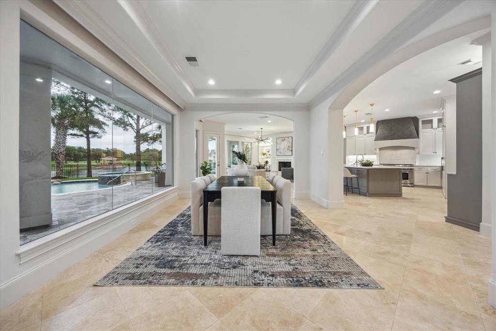 The thoughtfully redesigned first floor showcases a seamless flow between the dining, living, and kitchen areas, accented by designer finishes, lake views, and abundant natural light.