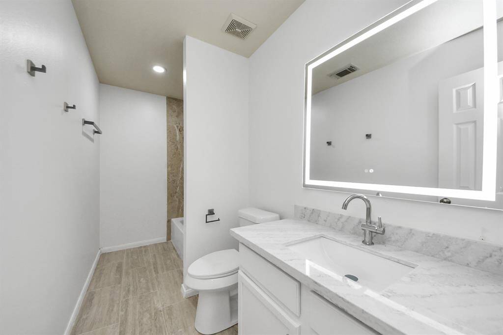 A complete bathroom remodel featuring brand-new flooring, tub, upgraded shower fixtures, handles on cabinets, Quartz countertops, a fresh sink, and all-new plumbing hardware. Plus don’t miss those stunning mirrors!