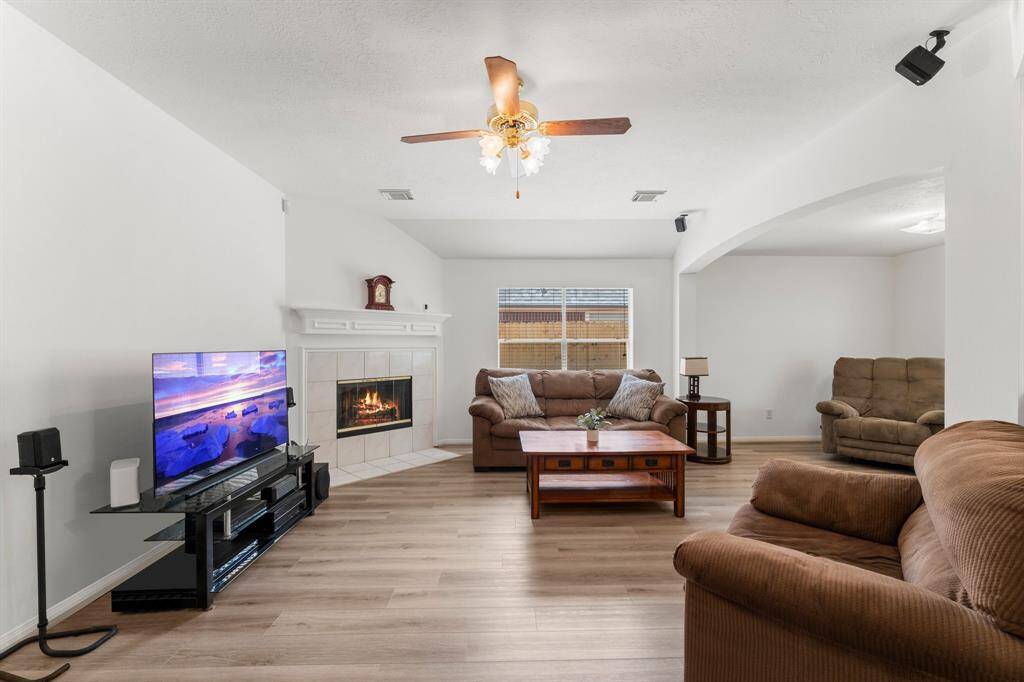 Family room has large window for natural light with beautiful fireplace and mantle.