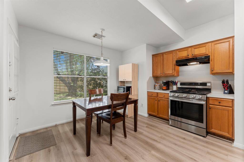 Good sized range with vent hood and stained cabinetry offers plenty of storage.