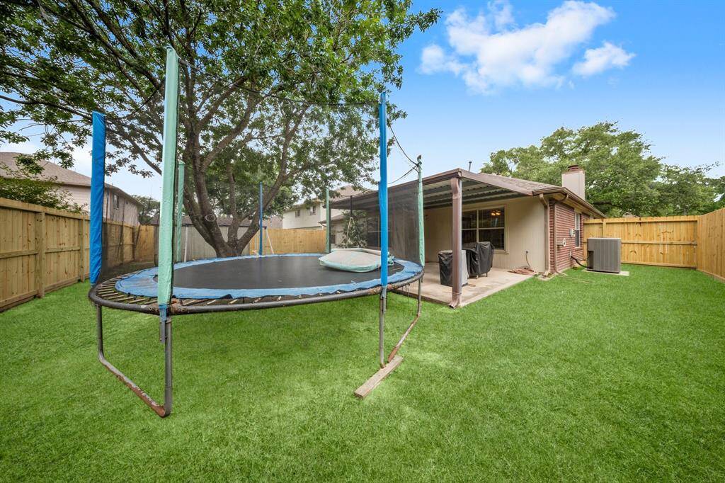 Nice size backyard with green lawn.