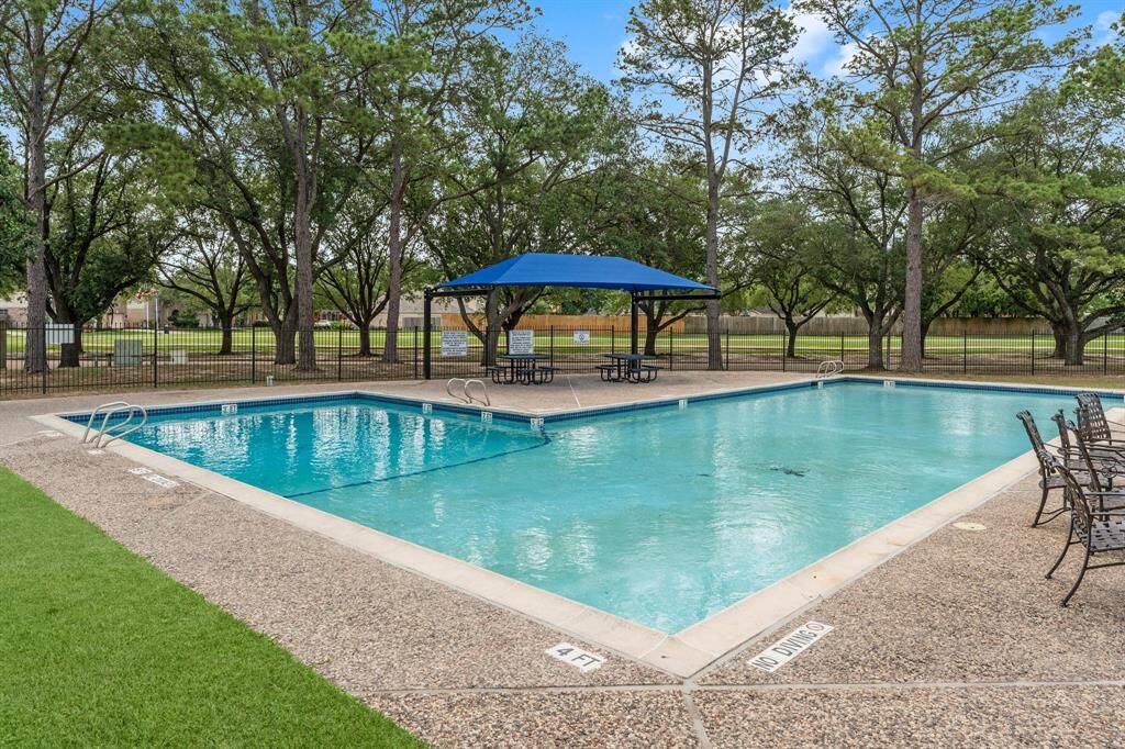 Large fenced in community pool and covered seating areas