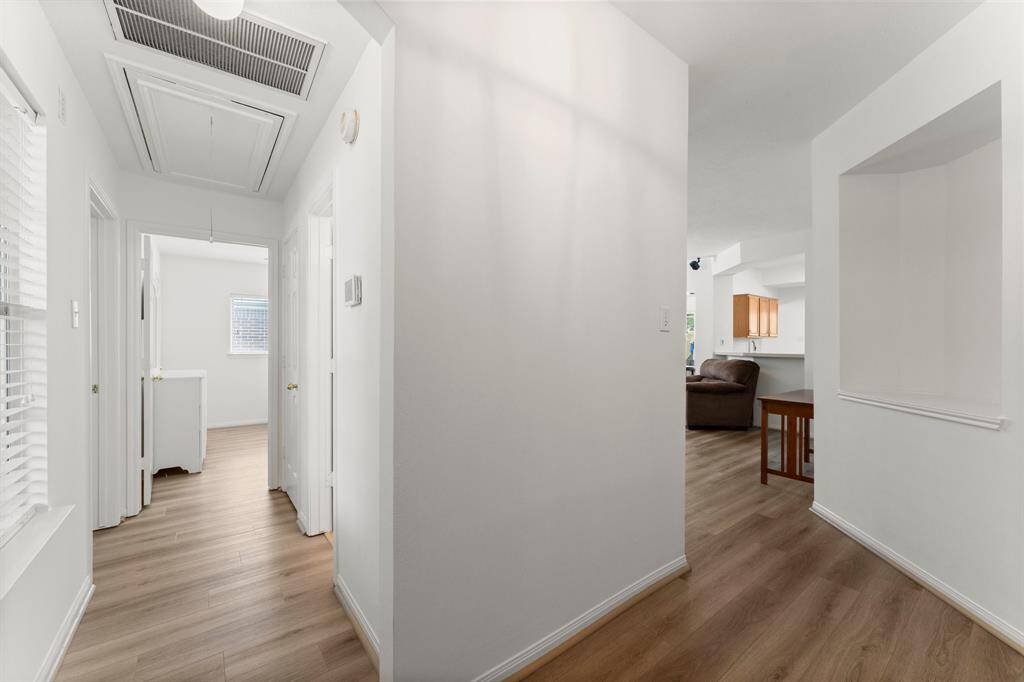 Entry hall to the left leads to 2 secondary bedrooms, and full bath. Entry hall to right leads to living/kitchen, and primary suite.