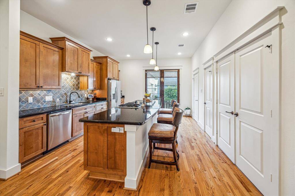 Upstairs is the kitchen with beautiful hardwood flooring