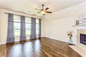 This spacious family room featuring laminate flooring and a cozy fireplace.