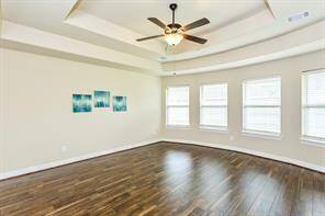 Retreat to the primary bedroom which features laminate flooring and tray ceilings.