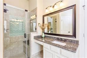 vanities with granite countertops in the primary bath. This one features a make-up area.