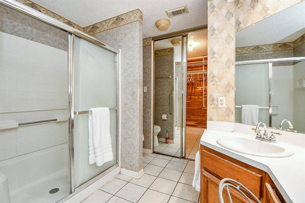 An oversized shower with a seat and a grab bar for safety.