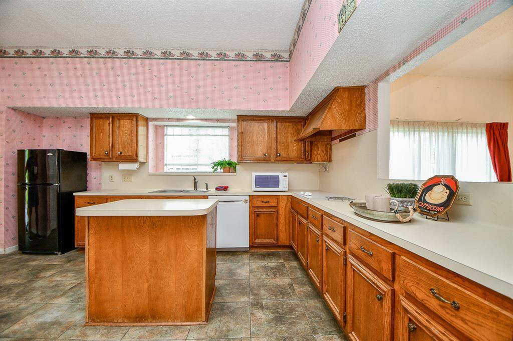 The refrigerator can stay, but it is not a full sized unit.