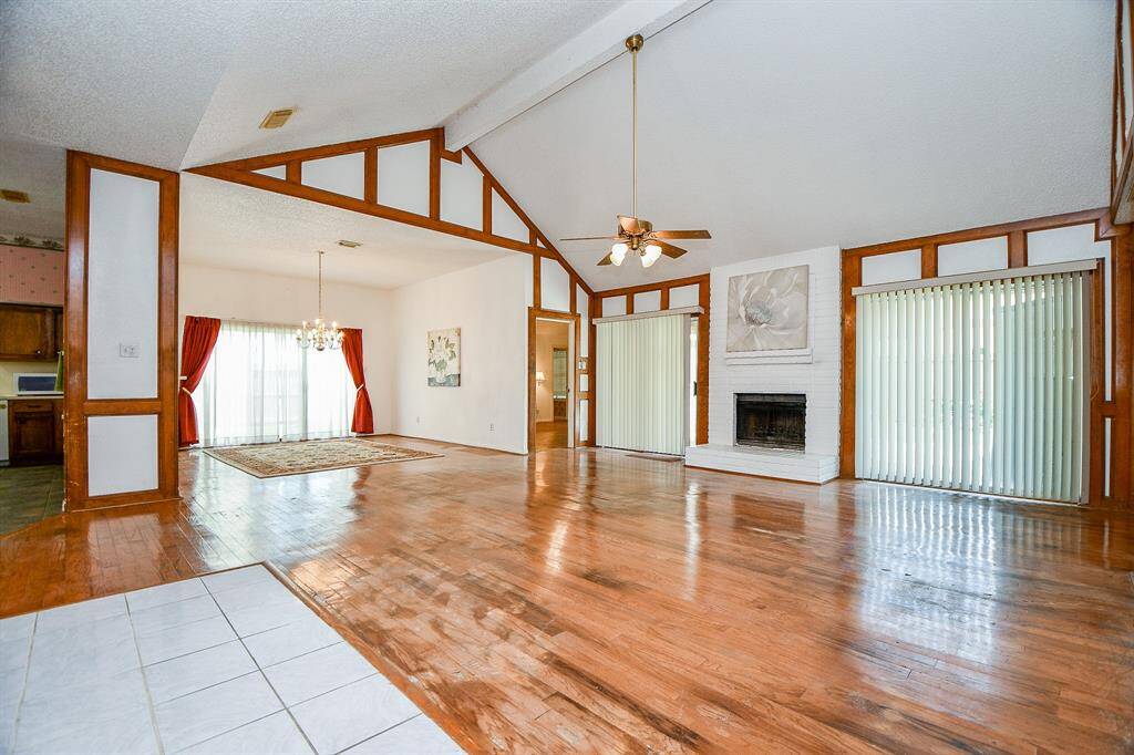 From this view you can see the location of the formal dining area. The fireplace facade is brick from the floor to the ceiling. Flanking the fireplace are sliding glass doors.