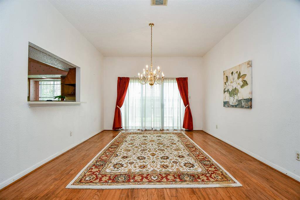 The brass chandelier is elegant. At the end of the room is another set of sliding glass doors and a small patio area perfect for a grill.
