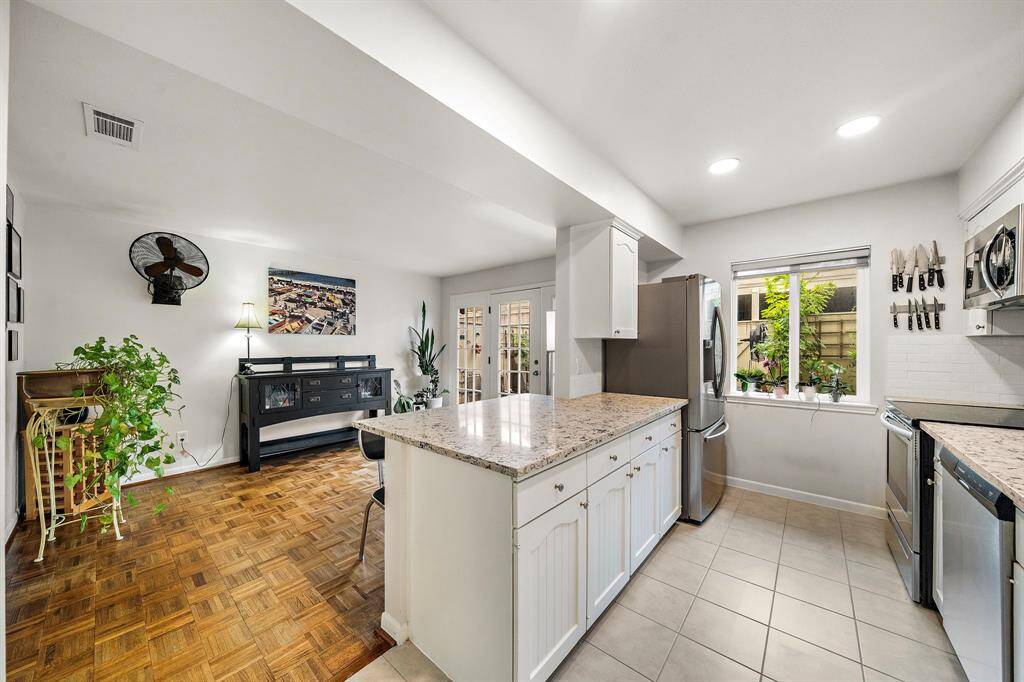 Semi-open kitchen. The breakfast bar offers additional sitting. The kitchen is renovated with quartz countertop, on trend white backsplash and new fridge. The kitchen is made from hardwood (including the drawers).