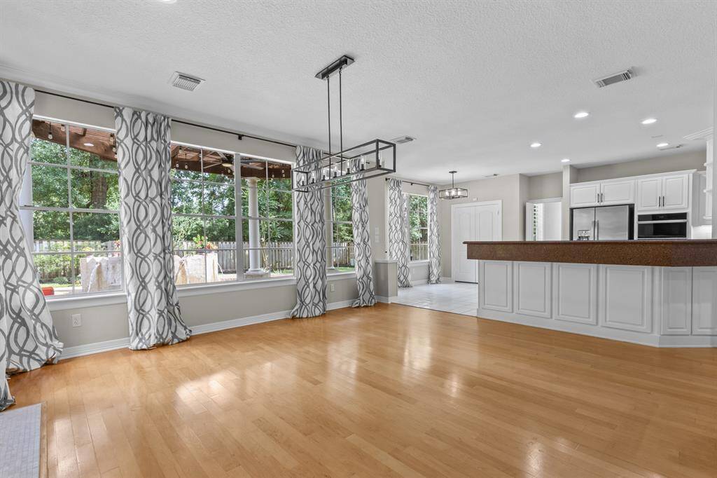 The Wall of windows allows for natural lighting and beautiful view of trees that line up along the back of the fence line.