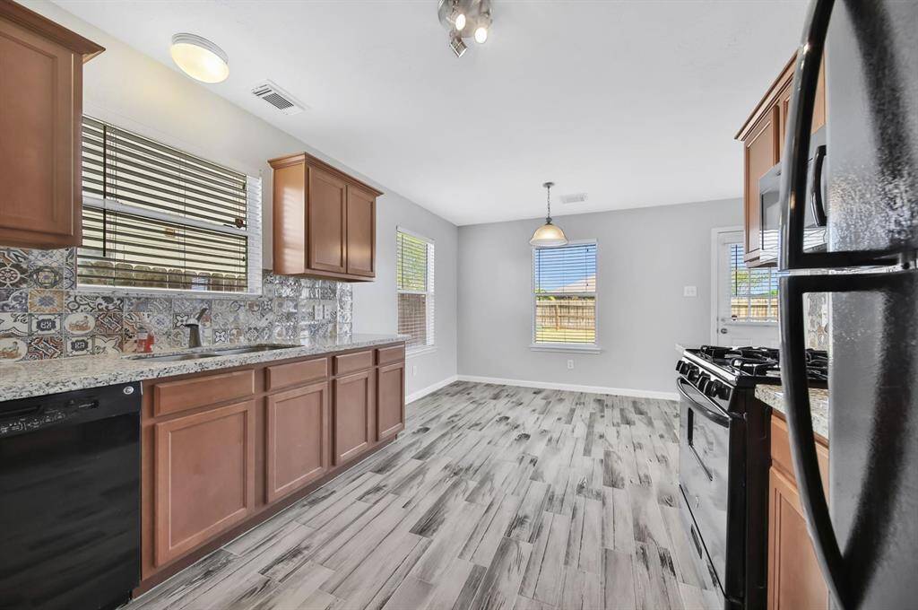 This stylish kitchen is fully equipped with granite countertops, ready-to-use appliances, and a gas stove.