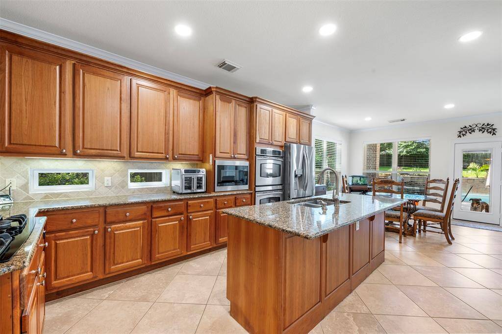 Expansive cabinetry, generous counter space, and a bright window line elevate this culinary space with natural light and warmth.