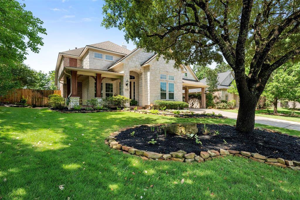 View of gorgeous front lawn with mature trees and professional landscaping.