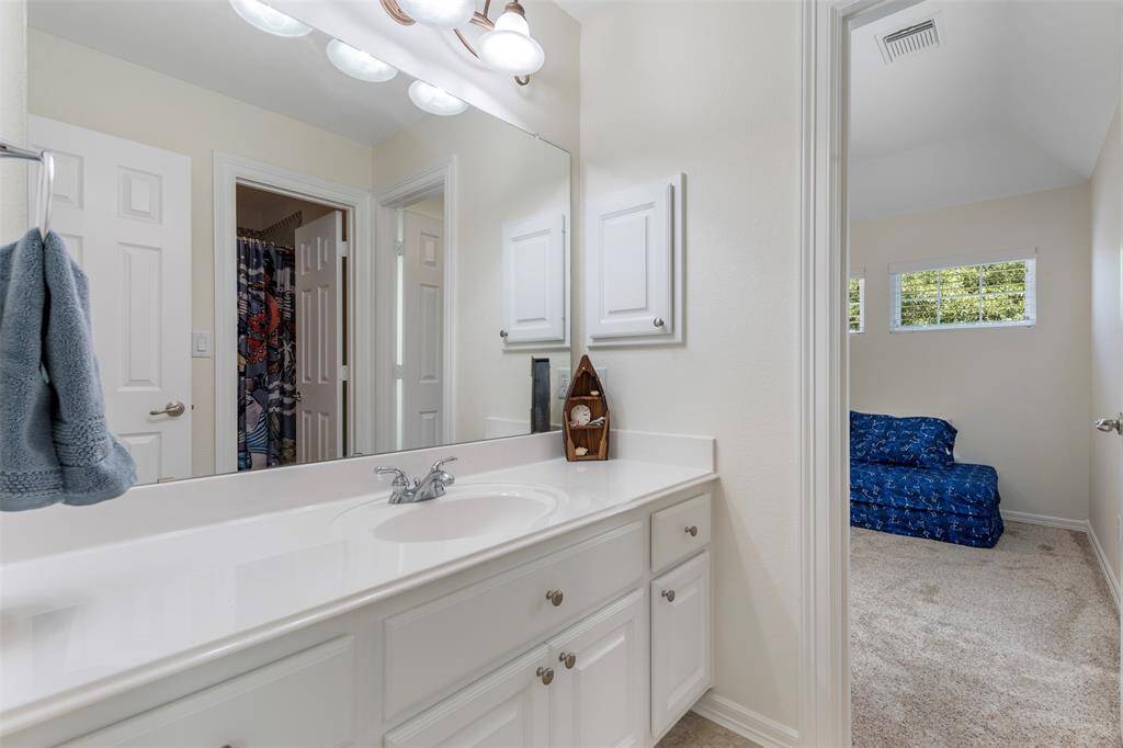 Jack-and-Jill style vanity with plenty of counter space and cabinetry, connecting two upstairs bedrooms