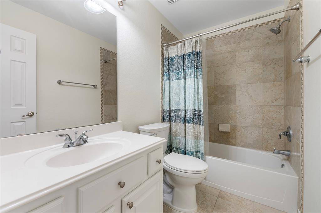 Full bathroom with tiled tub/shower combo and a wide vanity