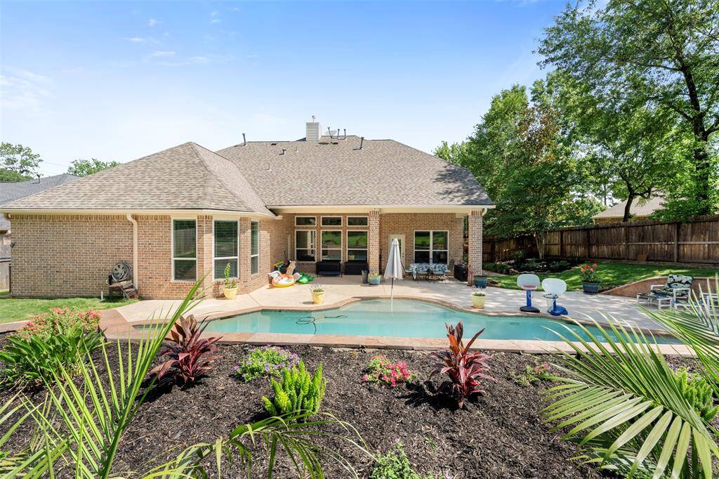 Rear elevation highlights the spacious covered patio and sparkling pool, perfect for sunny Texas afternoons