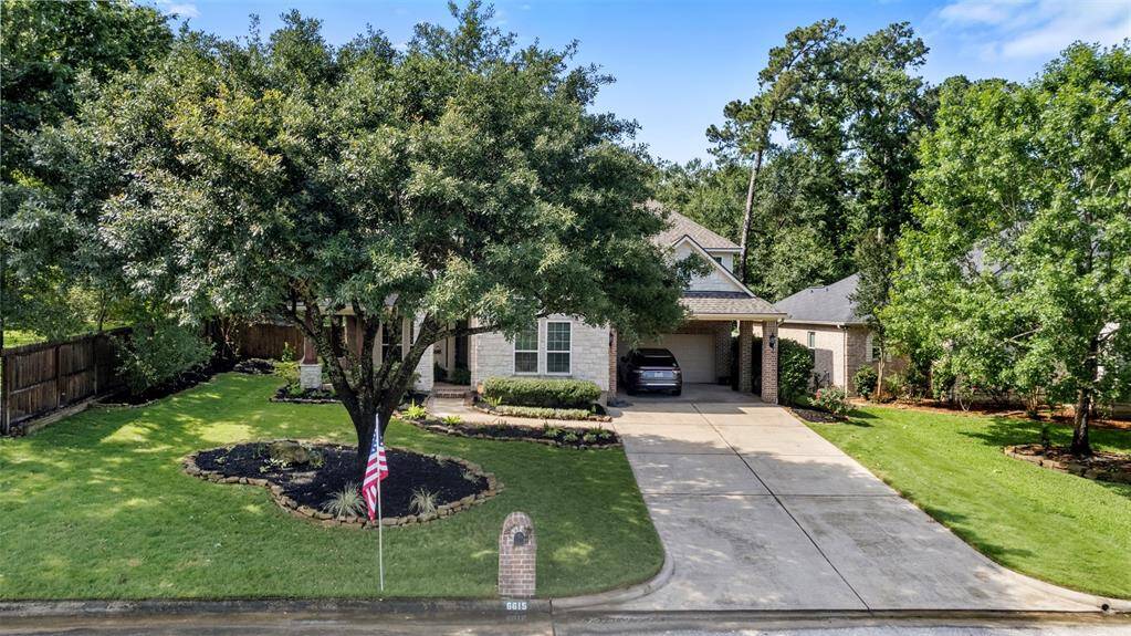 Wide-angle view captures the full grandeur of the home's front elevation, complete with shady trees and lush lawn