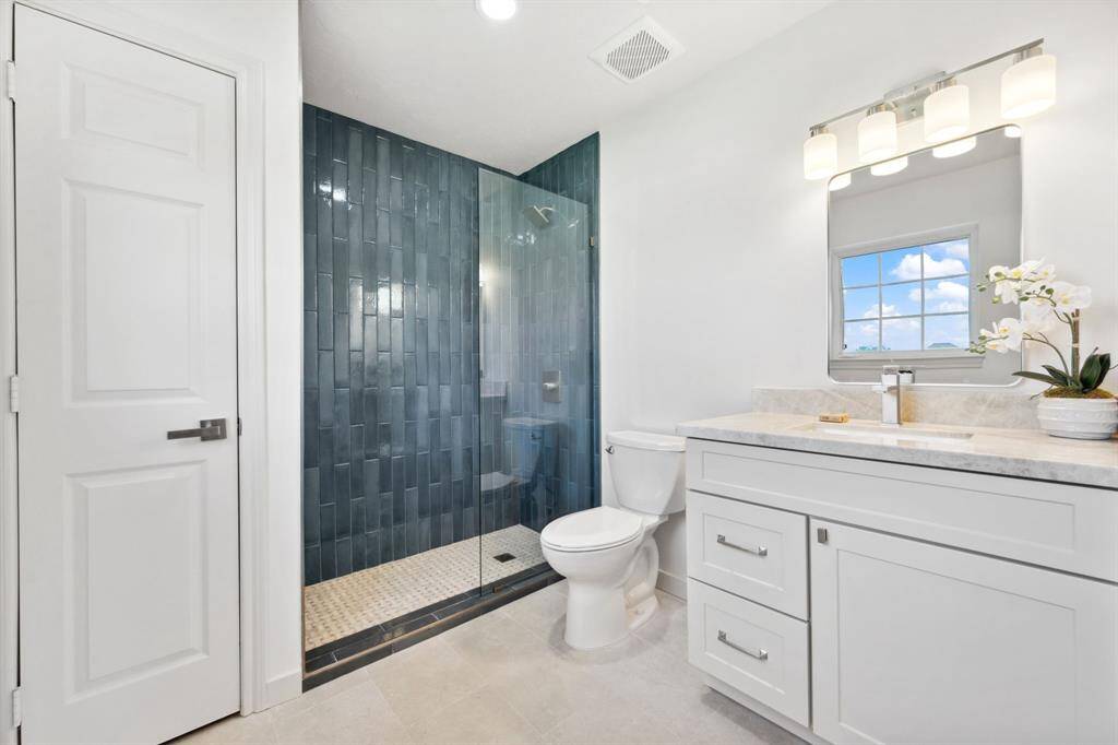 Primary bedroom features custom shower with soap niche and frameless glass, as well as a linen closet