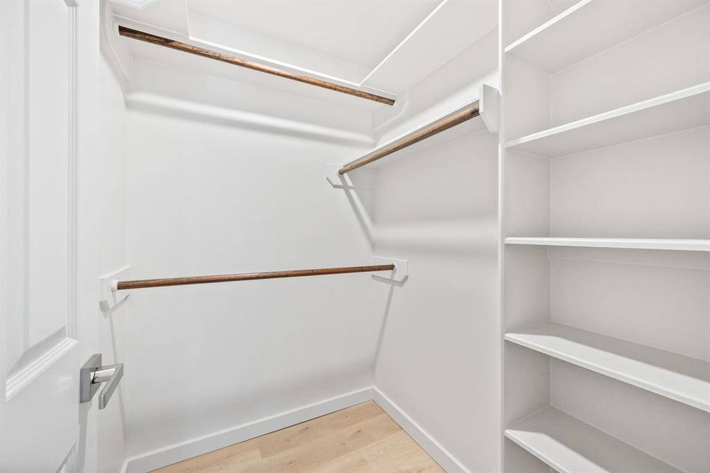 This bedroom features a walk-in closet with custom shelving