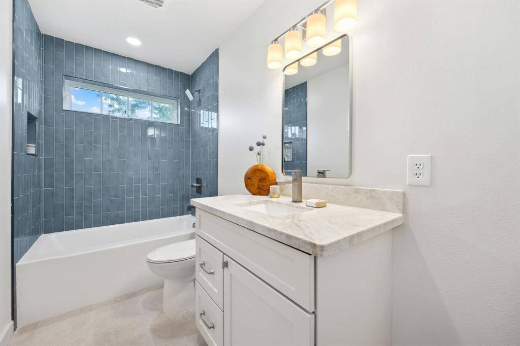 Generous hall bathroom with new tub and custom tile surround with soap niche